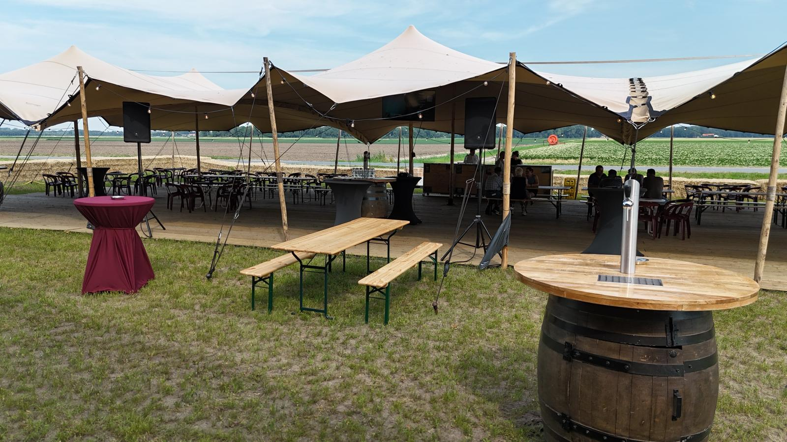 Stretchtenten met feestopstelling en tapton in het buitengebied